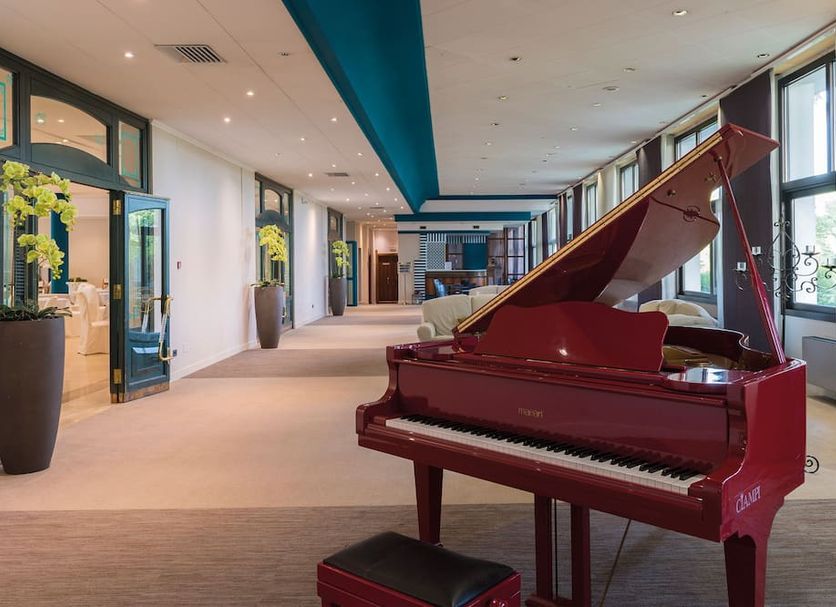 Hotel Salus Terme - Adults Only lobby in Viterbo with a red grand piano and bright windows