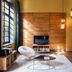 Stamba Hotel Tbilisi lounge with large window, wood slat wall, TV, lounge chair and coffee table