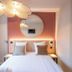 Bhoma Bourges - Hôtel room with double bed, round mirror, and modern ceiling light in Bourges