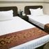 B&b Mongkok Hotel in Hong Kong, twin beds with white linens and patterned runners in a compact room
