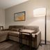 La Quinta Inn & Suites by Wyndham Montgomery room with sectional sofa, wall TV and floor lamp