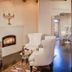 Palacio De Marquesa in Taos: elegant suite with fireplace, white chairs, and mirrored closet doors