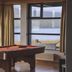 The Cliff Hotel in Neskaupstadur with a pool table and large windows overlooking the water