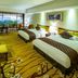 Guangzhou Phoenix City Hotel room with two twin beds and a balcony view of greenery in Guangzhou
