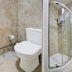 Belvilla Ilford Station Hotel bathroom with toilet, corner shower and sink in Ilford