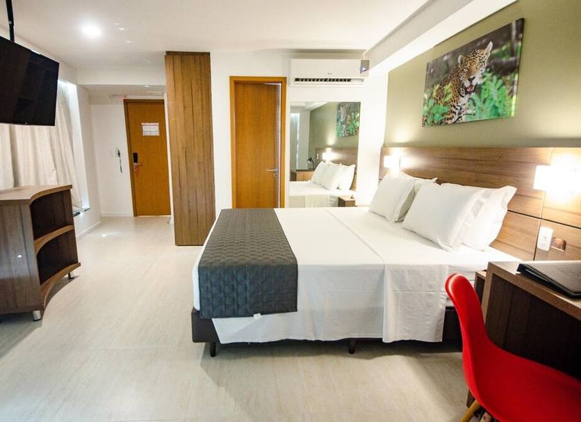Bristol Umarizal Belem guest room in Belém with queen bed, desk, wall TV and red chair