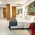 Bristol Umarizal Belem guest room in Belém with queen bed, desk, wall TV and red chair
