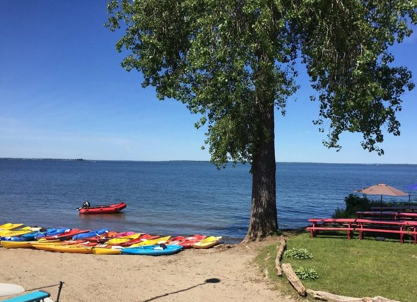 Manoir D'Youville in Châteauguay with a lakeside beach, kayaks, and picnic tables by the water