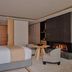Aman Rosa Alpina suite in Badia/Abtei with bed, fireplace, and lounge chair