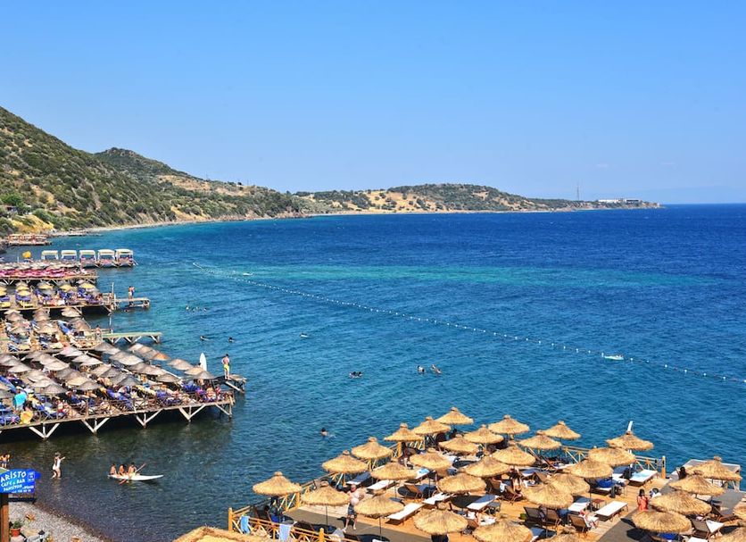 Assos Kervansaray Hotel - Special Category in Behram with beach loungers and parasols by a blue sea