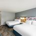 Hampton Inn Belle Vernon guest room with two beds, bedside lamp, and patterned carpet in Belle Vernon