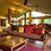 Mbuzi Mawe Serena Camp lounge in Serengeti with rustic sofas, wooden coffee table and large windows