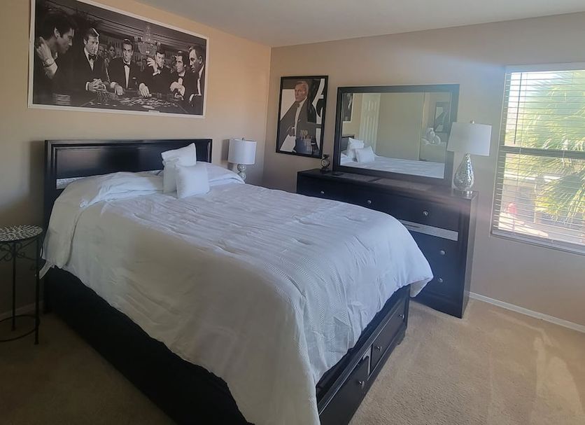 Happy Valley House Phoenix guest room with queen bed, dresser mirror, bedside lamps, and window light