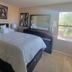 Happy Valley House Phoenix guest room with queen bed, dresser mirror, bedside lamps, and window light