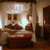 Knysna Manor House in Knysna bedroom with draped canopy bed and wooden bench