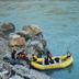 Ganga Beach Resort in Rishikesh with guests rafting beside rocky riverbank