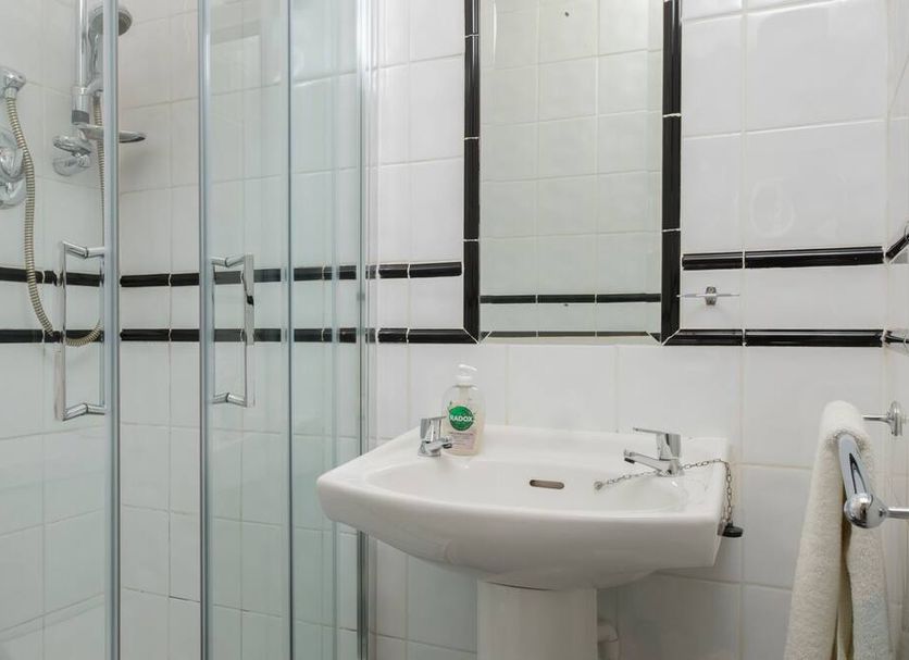 Four Seasons B&B Galway bathroom with glass shower, sink, and wall mirror