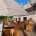 Vier Jahreszeiten Am Schluchsee terrace with wicker seating, large umbrella, and scenic lake view in Schluchsee
