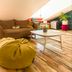 Loft - Hi Eco Hostel Reykjavik lounge with sofa, bean bag chair and coffee table under sloped ceiling