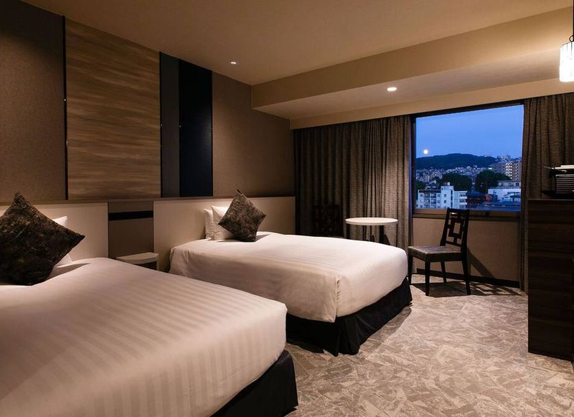Hotel Jal City Nagasaki guest room with two beds and city view through large window in Nagasaki