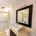 Sosua By The Sea bathroom with glass shower, vessel sink, toilet, and framed mirror in Sosúa