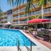 The Garden Hotel & Resort in Fort Lauderdale with palm-framed outdoor pool and patio seating