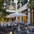 Le Cinq Codet Paris courtyard terrace with lounge seating, tables, umbrellas and warm evening lighting
