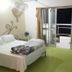 Eden Beach Saint-Louis bedroom with bed, balcony doors open to a terrace at night