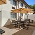 Baymont by Wyndham Branford/New Haven patio with picnic tables, umbrellas and sliding door to seating area