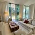 Lyfe Resort And Residences in Hollywood living room with sofa, TV, floor lamp and sliding doors to palm-view patio