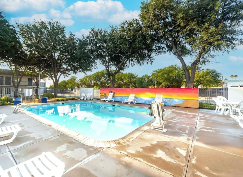 Motel 6 Del Rio, TX outdoor pool with lounge chairs and colorful privacy wall