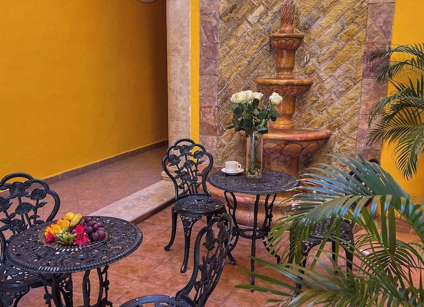 Maya Campeche Hotel in Campeche courtyard seating with wrought-iron tables, chairs, fountain and plants
