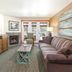 Worldmark Deer Harbor living room with striped sofa, fireplace, TV, and deck doors