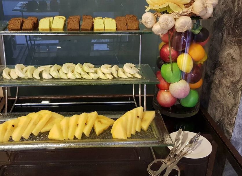 DeHome Boutique Hotel Kuching breakfast display with sliced fruit, pastries, and fruit arrangement