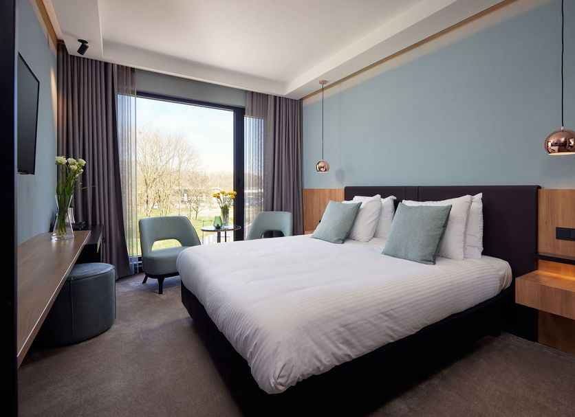 Van der Valk Hotel Gorinchem-A27 guest room with king bed, balcony view, and modern seating