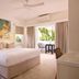 Atlantic Byron Bay room with king bed, balcony, palm view and tropical artwork