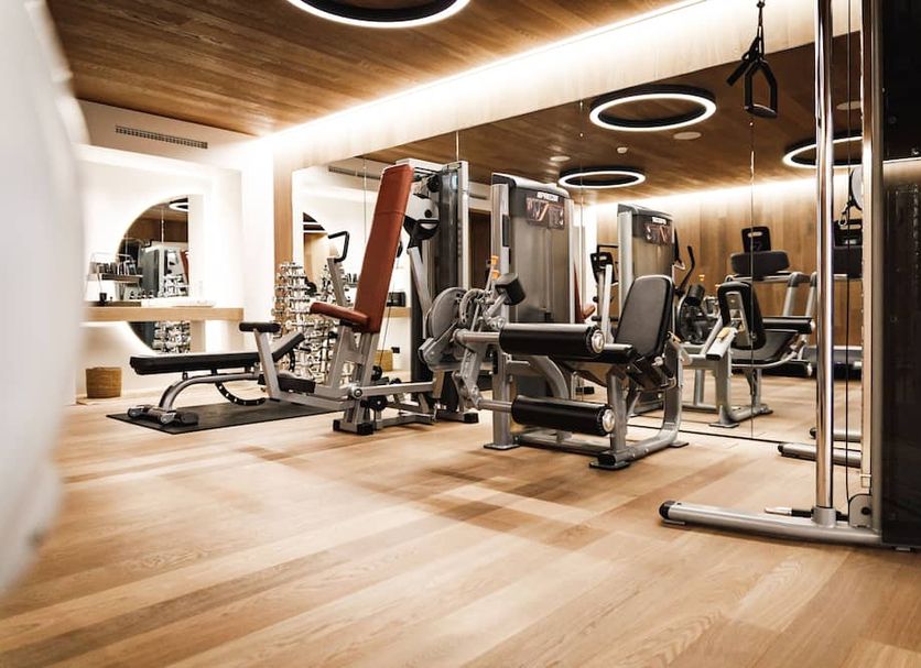 Sonnhof Alpendorf in Sankt Johann im Pongau gym with exercise machines and wood-paneled ceiling
