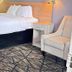 Americas Best Value Inn & Suites Senatobia room with bed, nightstand and upholstered chair
