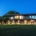Domaine de Bayeux in Bayeux, exterior of the hotel at dusk with lit windows and lawn