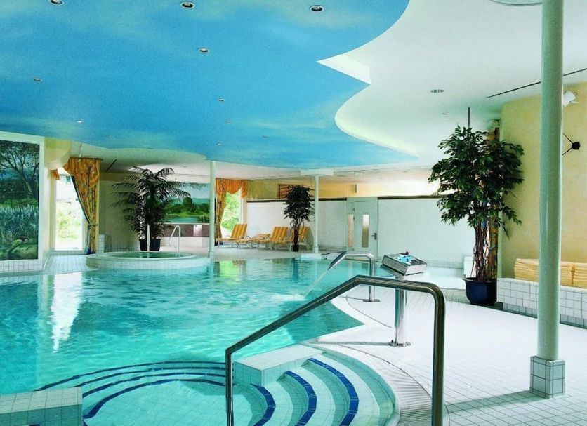 Indoor pool at Landhaus Zu den Rothen Forellen in Ilsenburg with curved ceiling and lounge chairs