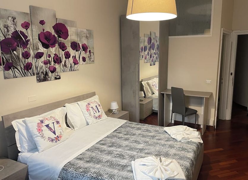 Villa Mase in Ravenna guest room with king bed, floral wall art, desk, and hardwood floor
