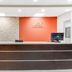 Baymont by Wyndham Midland Airport lobby front desk in Midland with orange accent wall