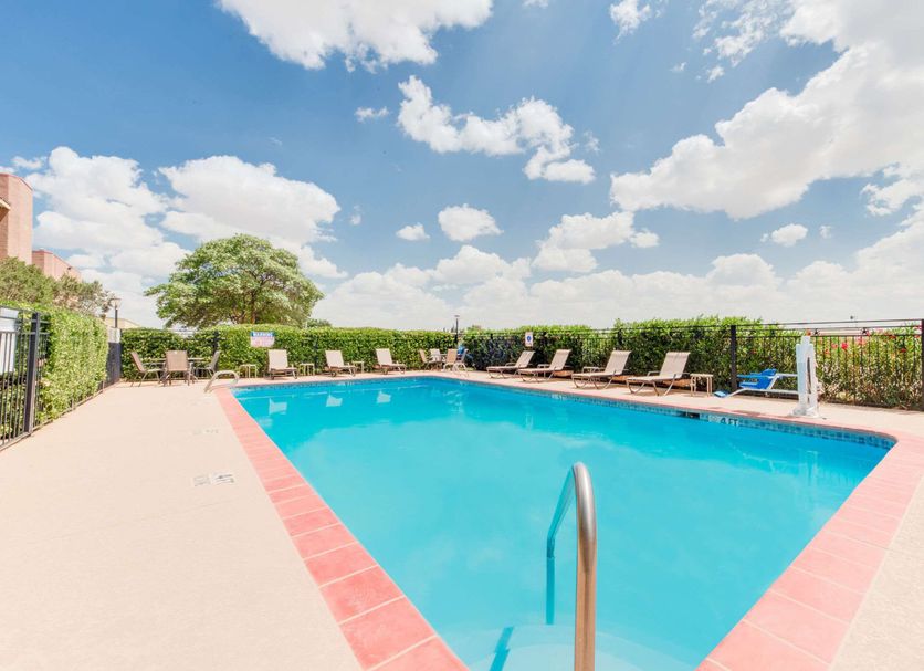 Baymont by Wyndham Midland Airport pool with lounge chairs and blue sky in Midland