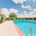 Baymont by Wyndham Midland Airport pool with lounge chairs and blue sky in Midland