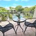 Noosa River Retreat in Noosa Heads balcony with chairs, table, and pool and garden views