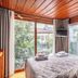 Atelya Art Hotel Antalya room with bed, wall-mounted TV and large windows overlooking greenery