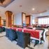 Hotel Devi Grand in Katra dining room with set tables, wicker chairs, and bright windows