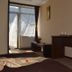 Magic Club Bușteni guest room with bed, desk, balcony door, and mountain light through sheer curtains