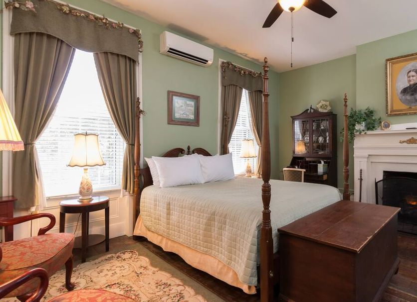 Munro House B And B in Jonesville bedroom with four-poster bed, fireplace, and sitting area