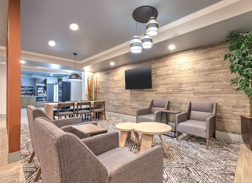 Candlewood Suites Houston (The Woodlands) By IHG lobby seating area with wall-mounted TV and wood-accent wall